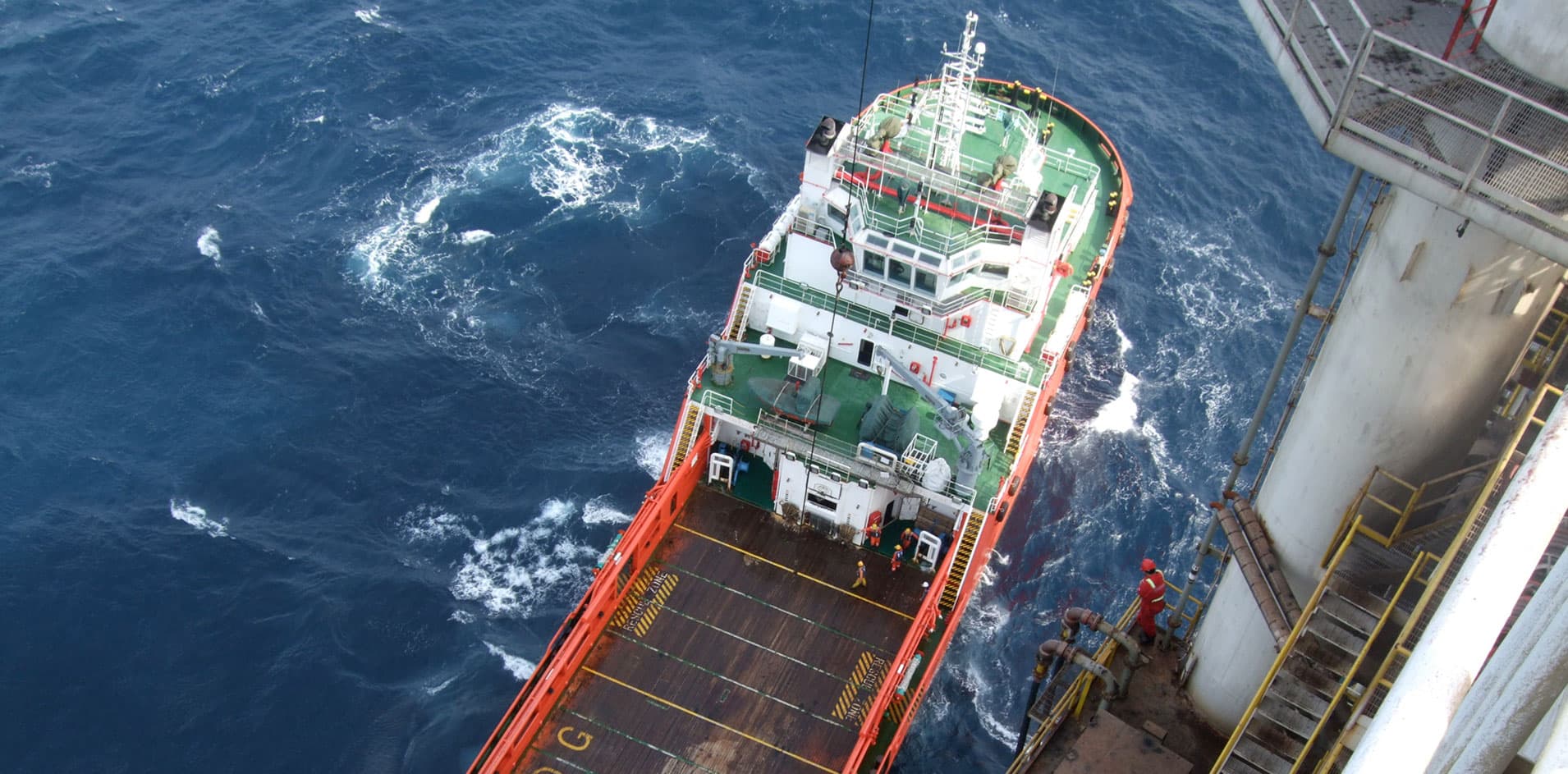 Offshore support vessel transferring material supply to drilling rig
